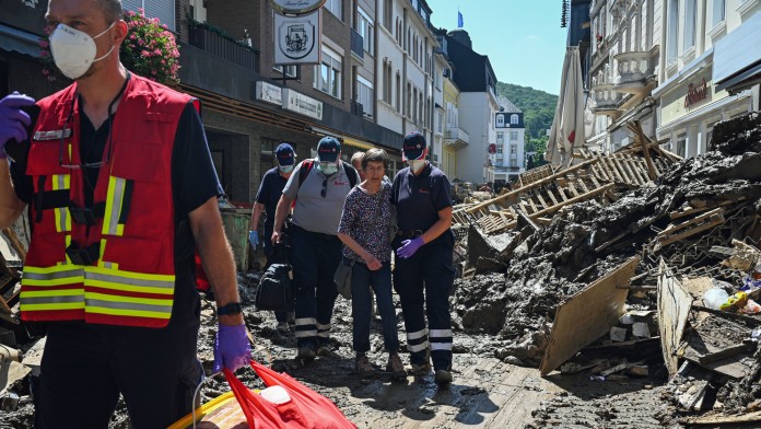 Helfende der Johanniter in Bad Neuenahr-Ahrweiler begleiten eine Seniorin aus ihrer Wohnung.