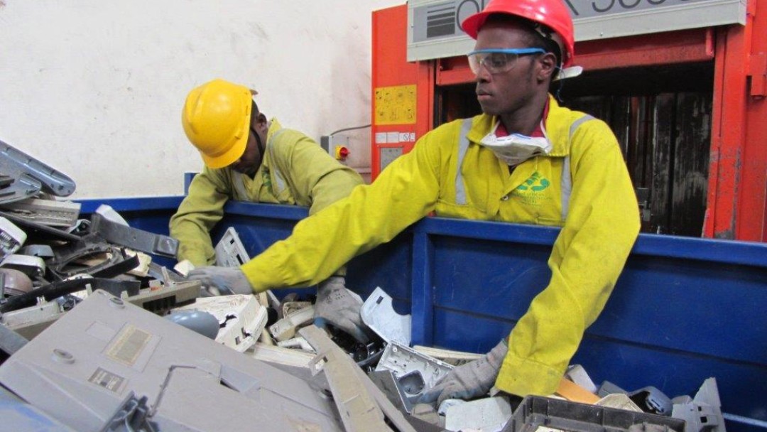 Two men working in a collection point for electronic devices.