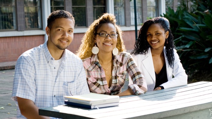 Three African students are sitting around a table.
