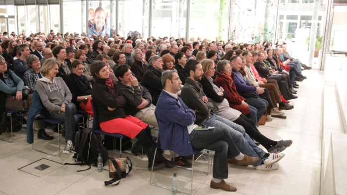 Personen im Publikum lauschen einer Lesung